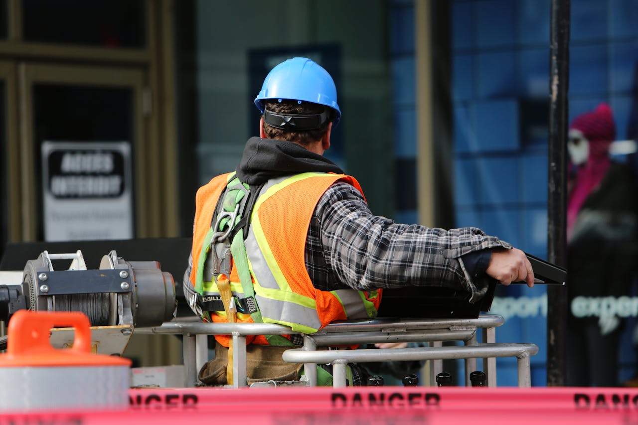 Crafting Captivating Headlines: Your awesome post title goes here A construction worker wearing a blue helmet and safety vest operates equipment at an urban construction site.